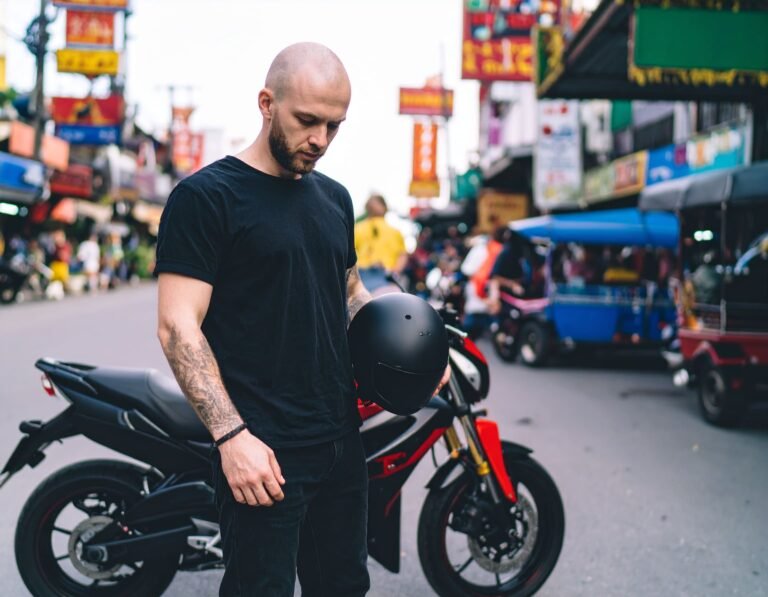 Bangkok expat with helmet in hand standing to his long-term motorcycle rental